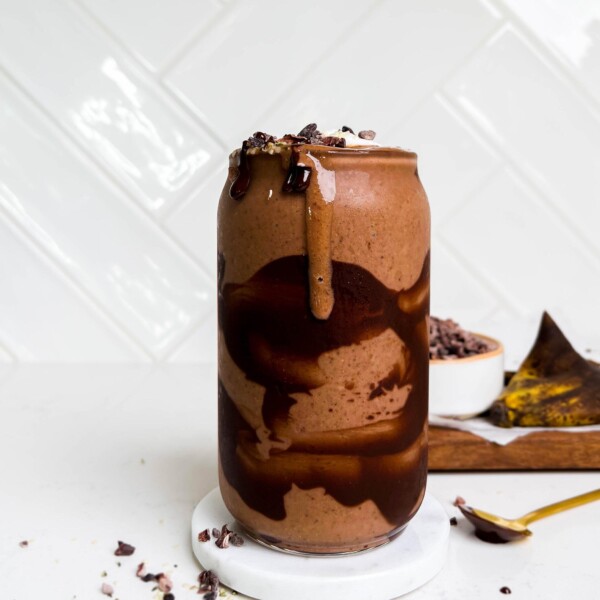 a glass of dark chocolate smoothie with chocolate swirls