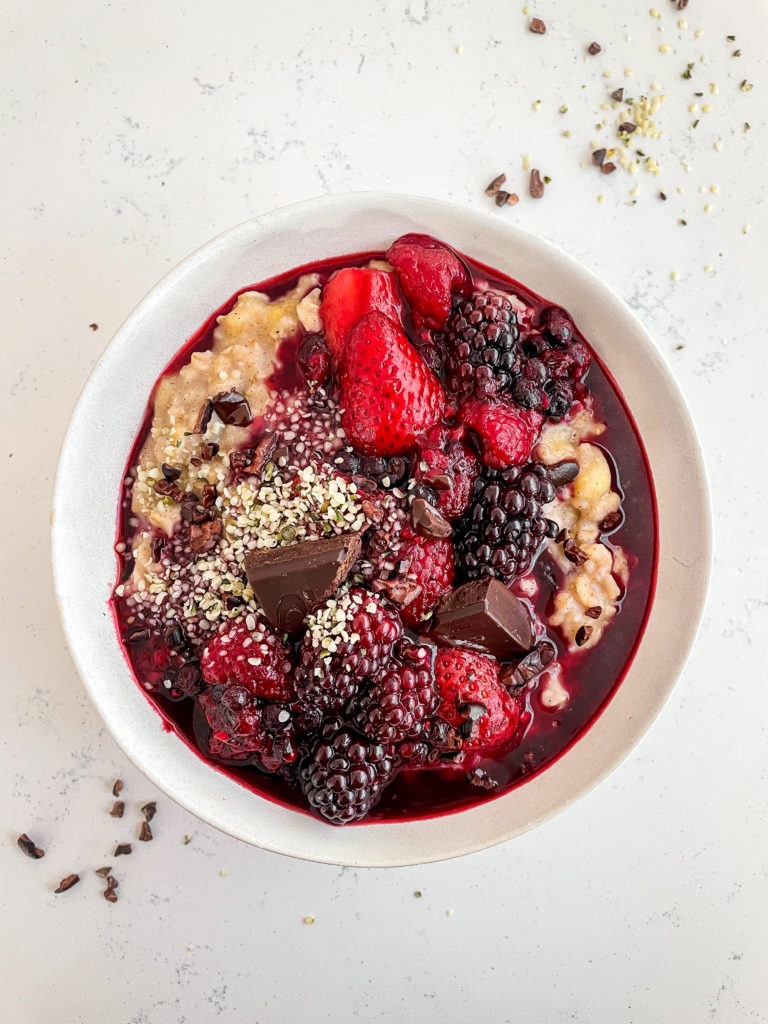 vanilla and cinnamon oatmeal with berry compote and chocolate on top 
