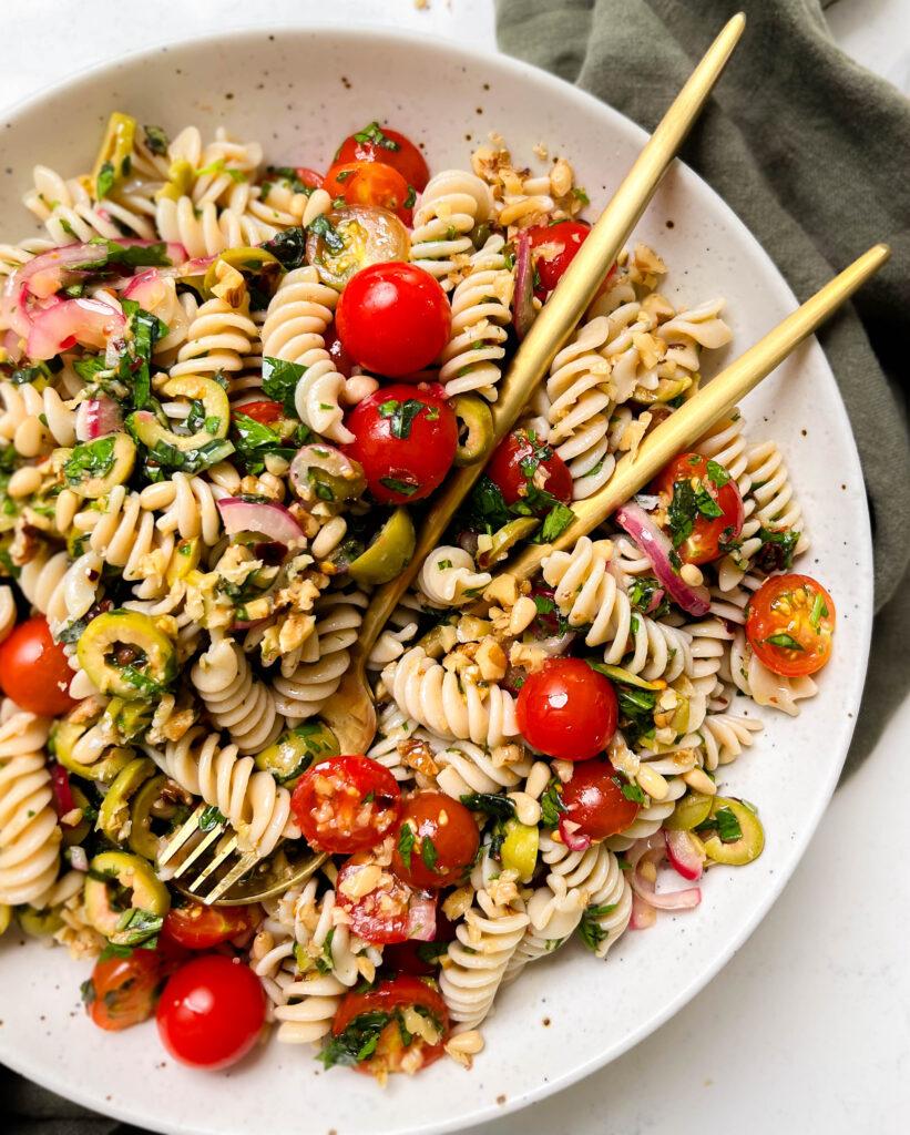 vegan pasta salad in a speckled bowl on a green linen cloth