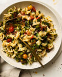 cherry tomato pasta salad in a speckled bowl