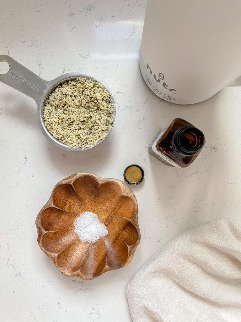 an array of ingredients for nut milk, cashews, salt, vanilla extract and coconut sugar. 