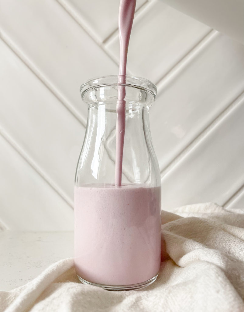 strawberry cashew milk poured into a mason jar 
