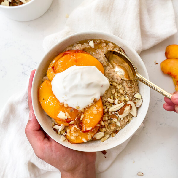 almond oatmeal with caramelized peaches and coconut yogurt on top