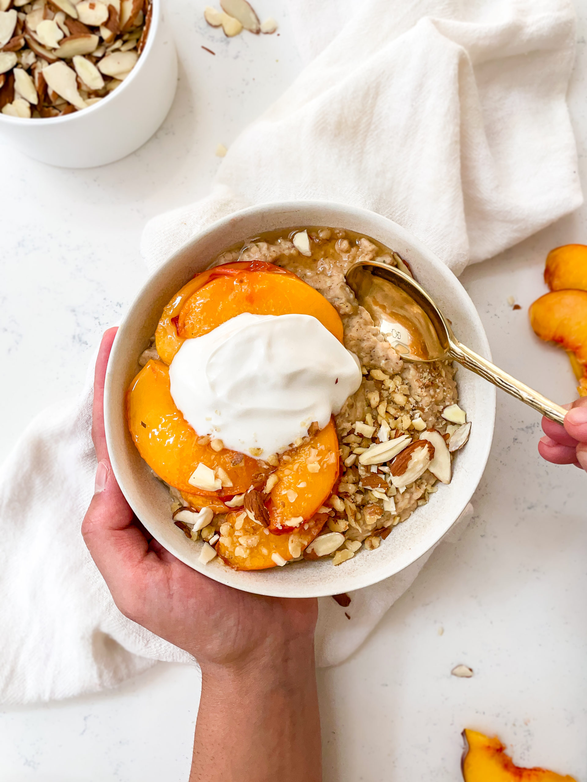 almond oatmeal with caramelized peaches and coconut yogurt on top