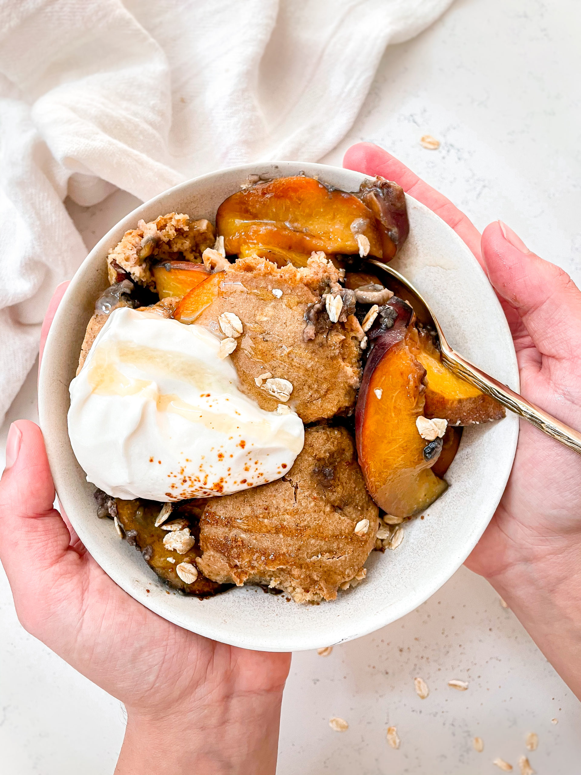 healthy peach cobbler baked oats made from oats, peaches and vegan coconut yogurt