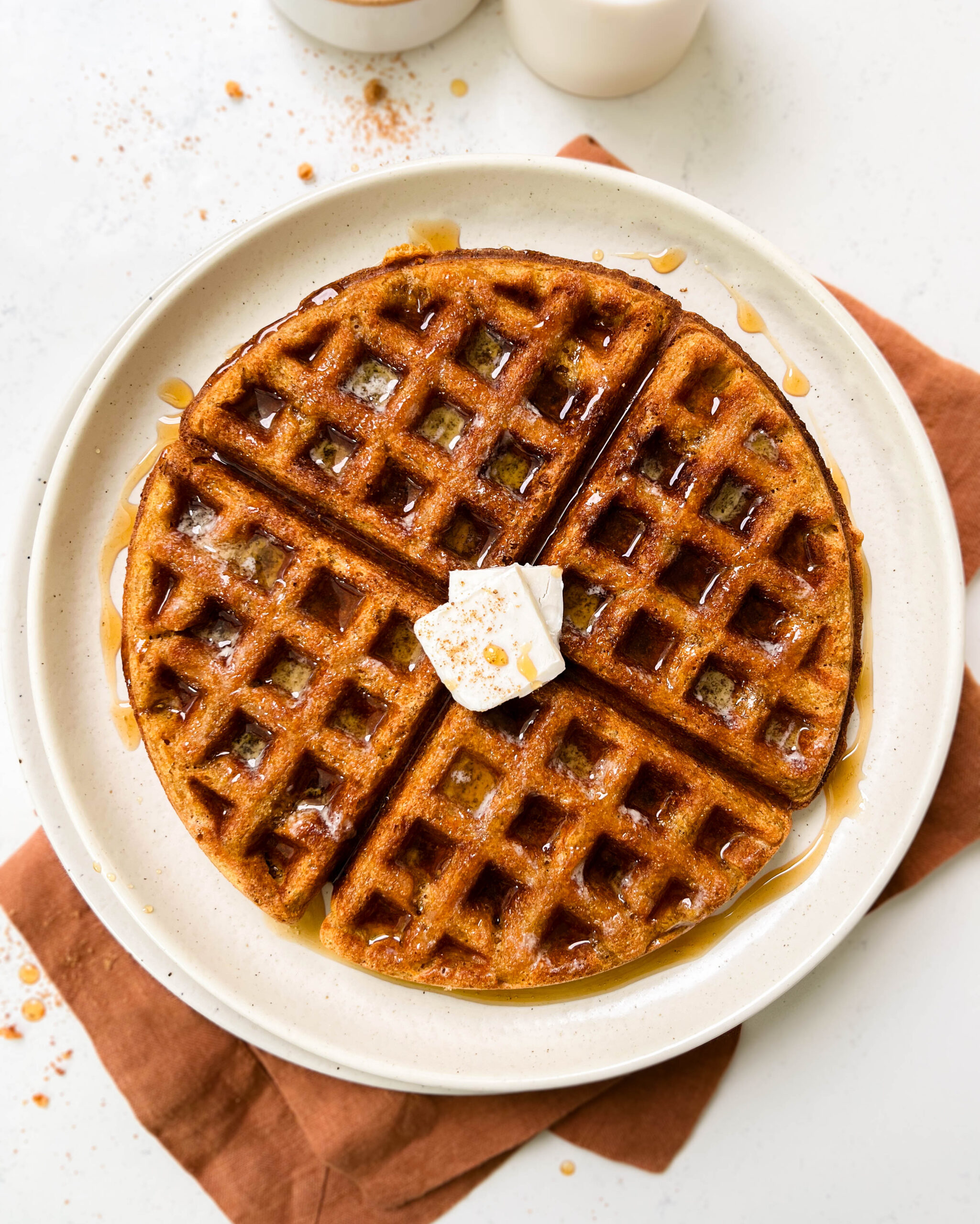 buttery pumpkin waffle on a beige plate