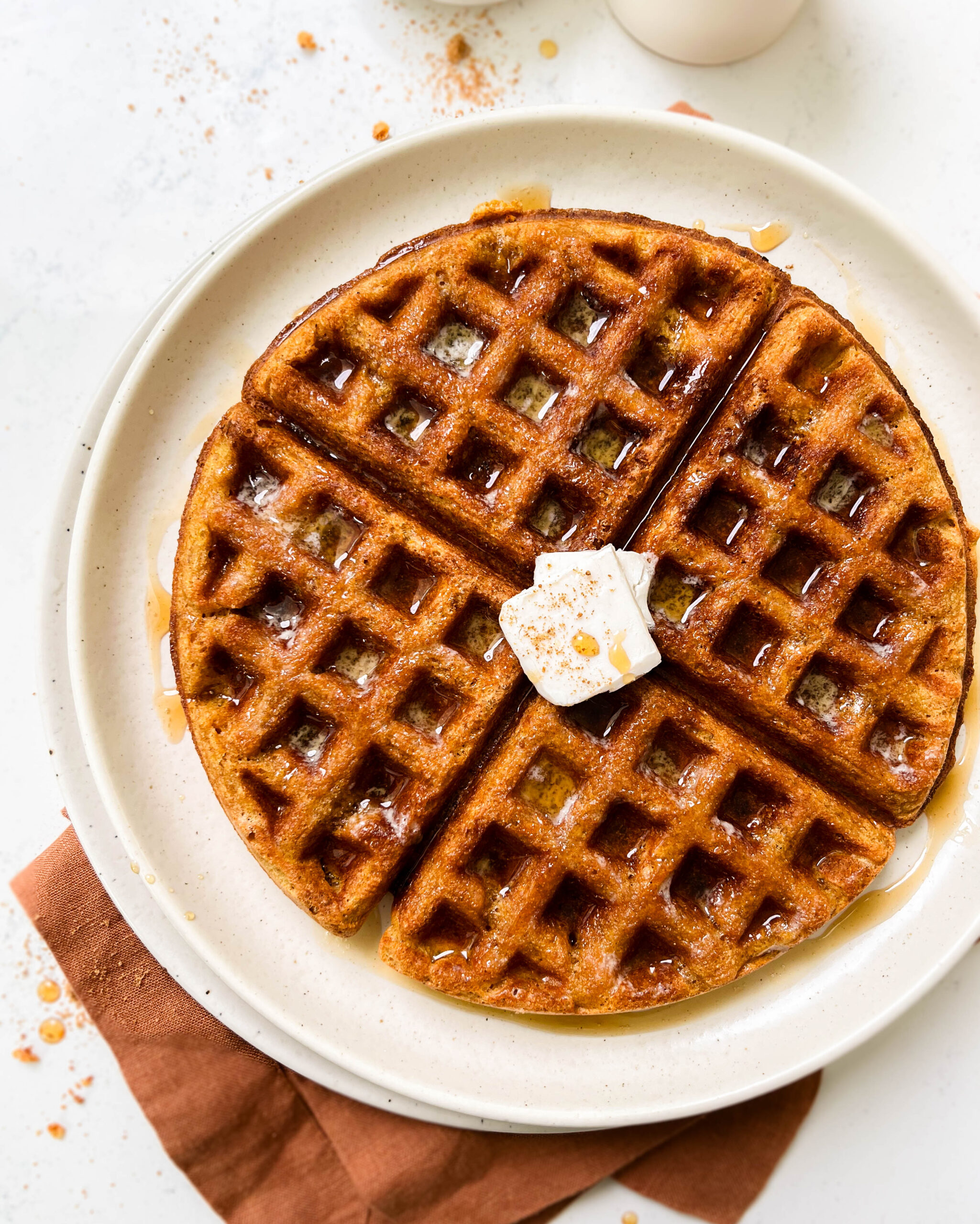 buttery pumpkin waffle on a beige plate