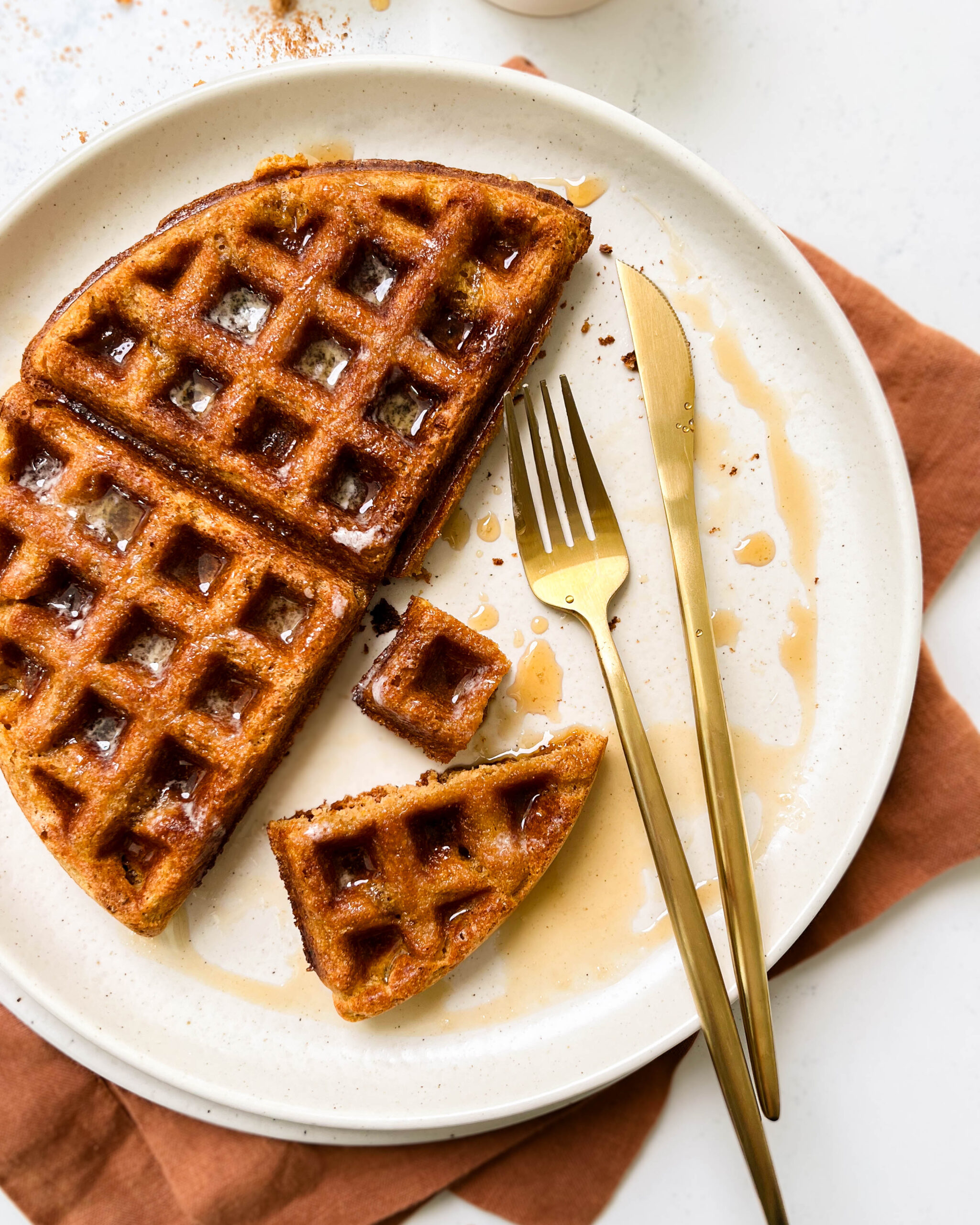 buttery pumpkin waffle on a beige plate