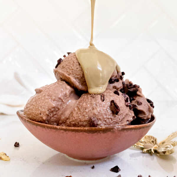 chocolate nice cream in a bowl covered in peanut butter