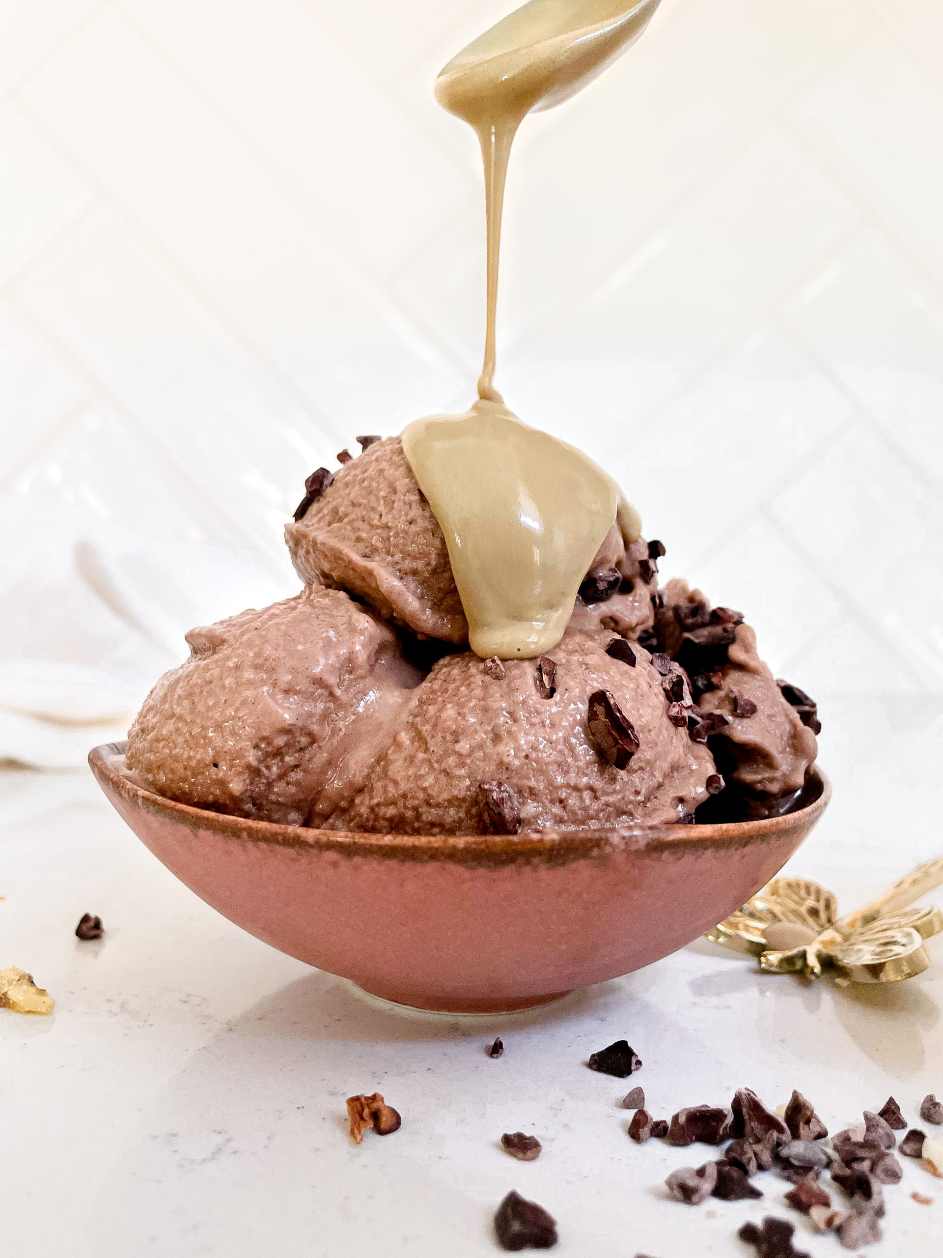 chocolate nice cream in a bowl covered in peanut butter