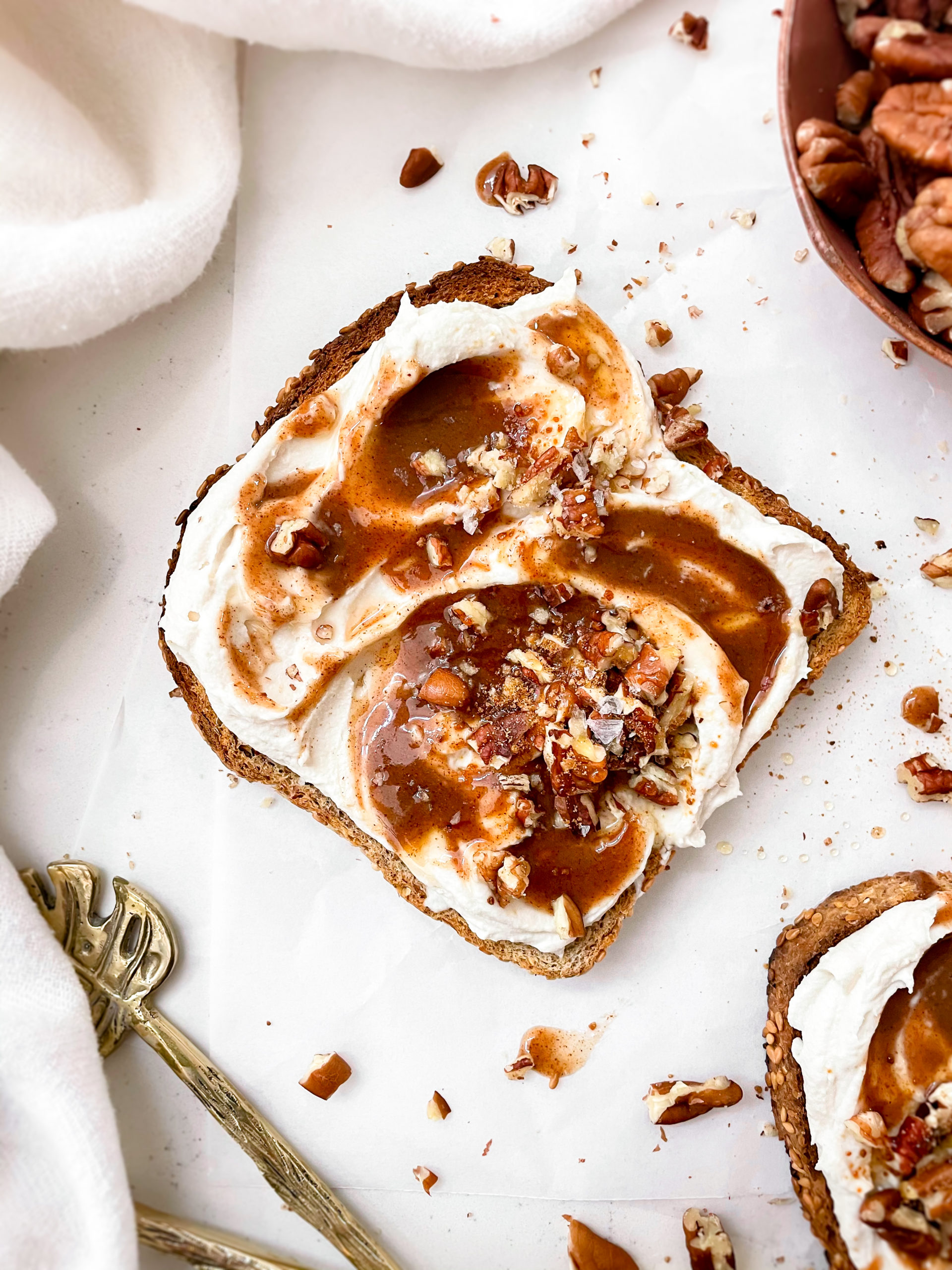 crispy ezekiel bread with vanilla cream cheese and cinnamon sugar syrup with crushed pecans on top