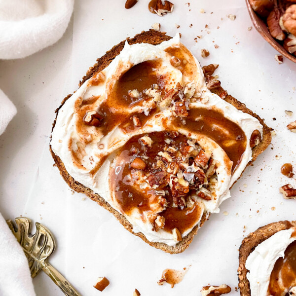 crispy ezekiel bread with vanilla cream cheese and cinnamon sugar syrup with crushed pecans on top