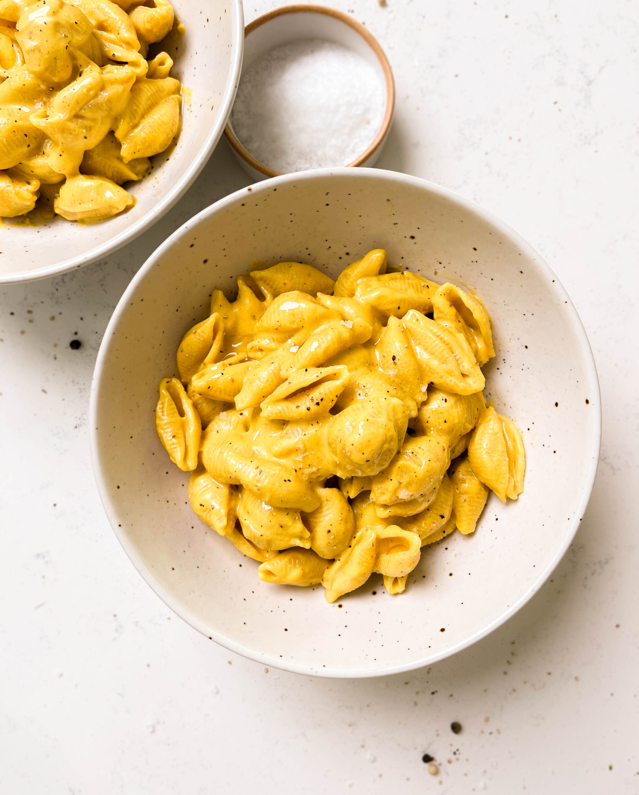 two white bowls of vegan butternut squash mac and cheese