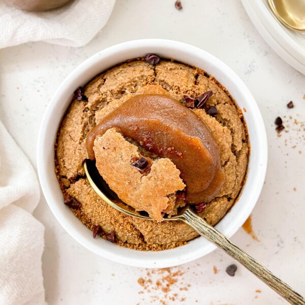 healthy date caramel baked oats with a gold spoon next to plates and spoons