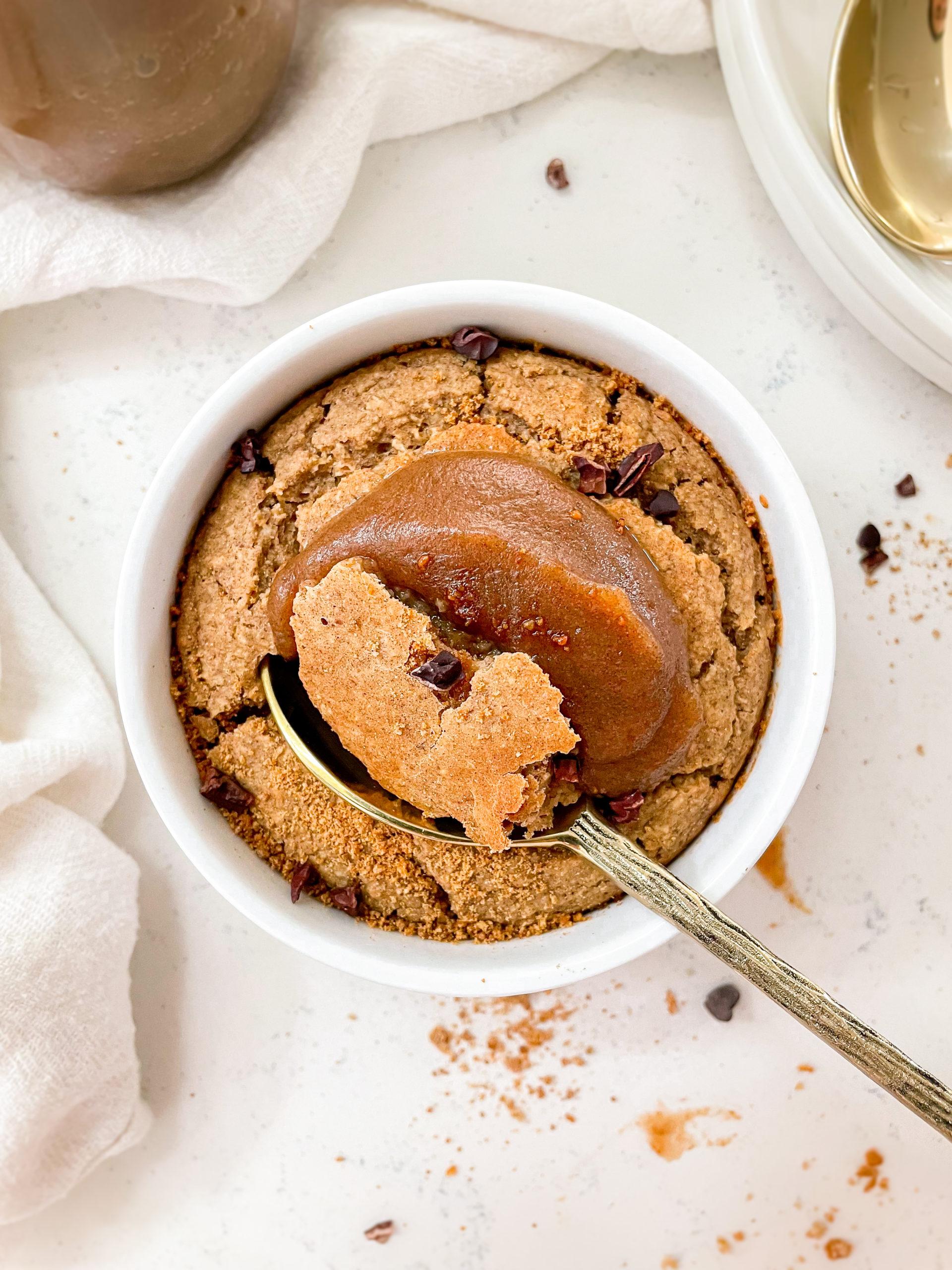 healthy date caramel baked oats with a gold spoon next to plates and spoons
