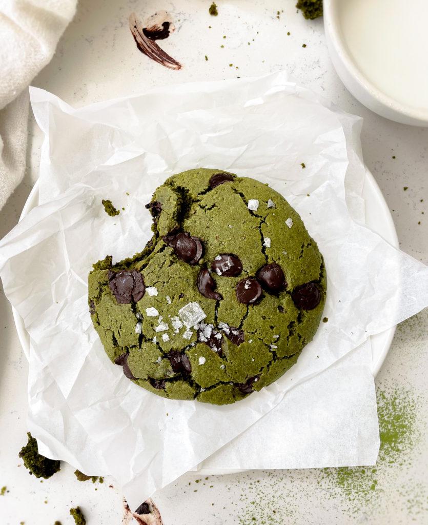 matcha cookie on a plate next to a glass of milk