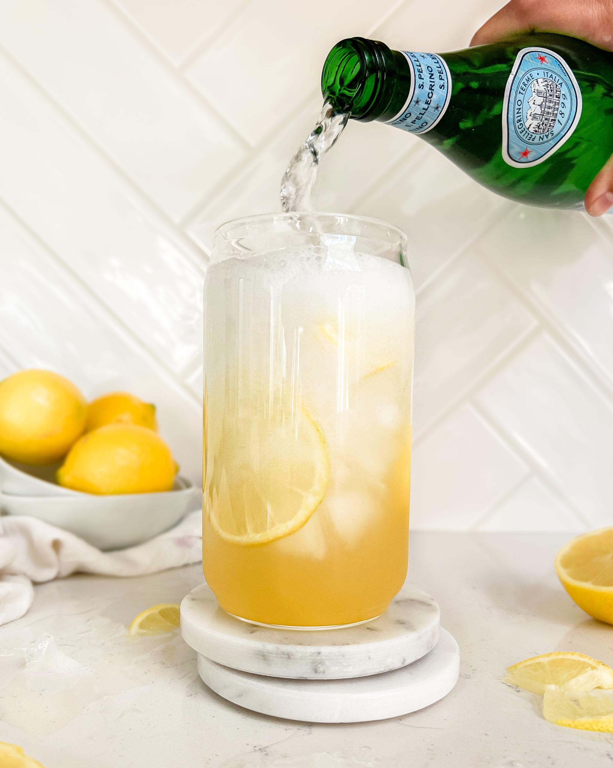 sparkling water poured into a glass of lemonade