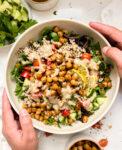 bowl with chickpeas, quinoa, greens and veggies next to a white linen napkin