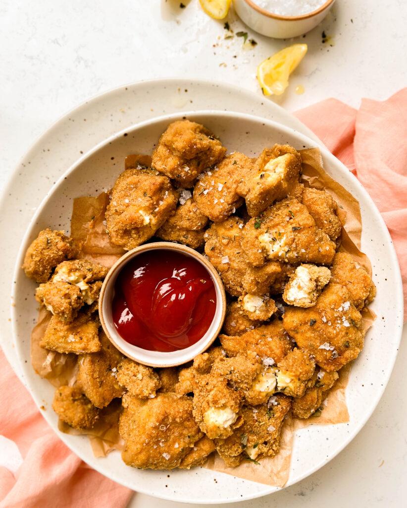 crispy baked tofu nuggets in bowl with a bowl of ketchup