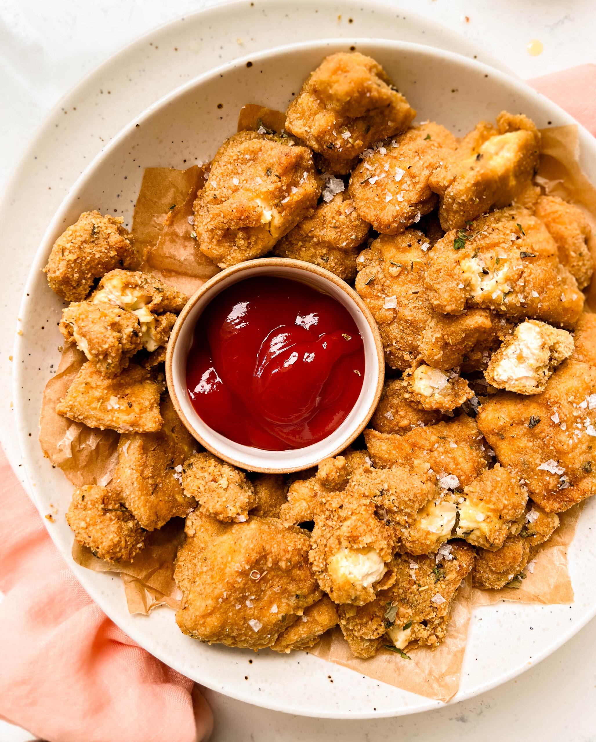 crispy baked tofu nuggets in bowl with a bowl of ketchup