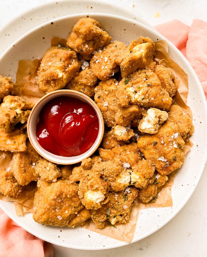 crispy baked tofu nuggets in bowl with a bowl of ketchup