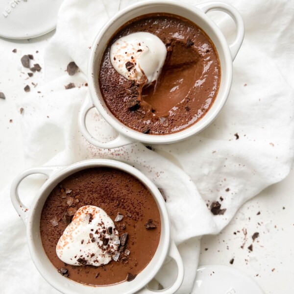 vegan chocolate pudding in a white ramekin with coconut yogurt and chocolate on top