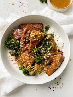 marinated peanut tempeh with white rice and broccoli next to a white linen cloth