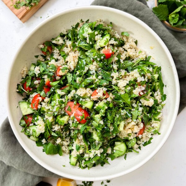 tabbouleh salad in a white bowl on a green linen cloth