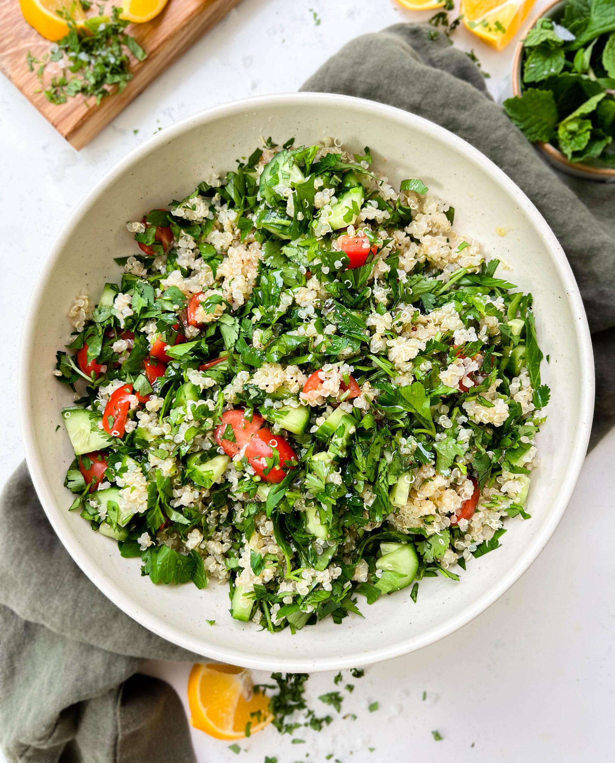 tabbouleh salad in a white bowl on a green linen cloth