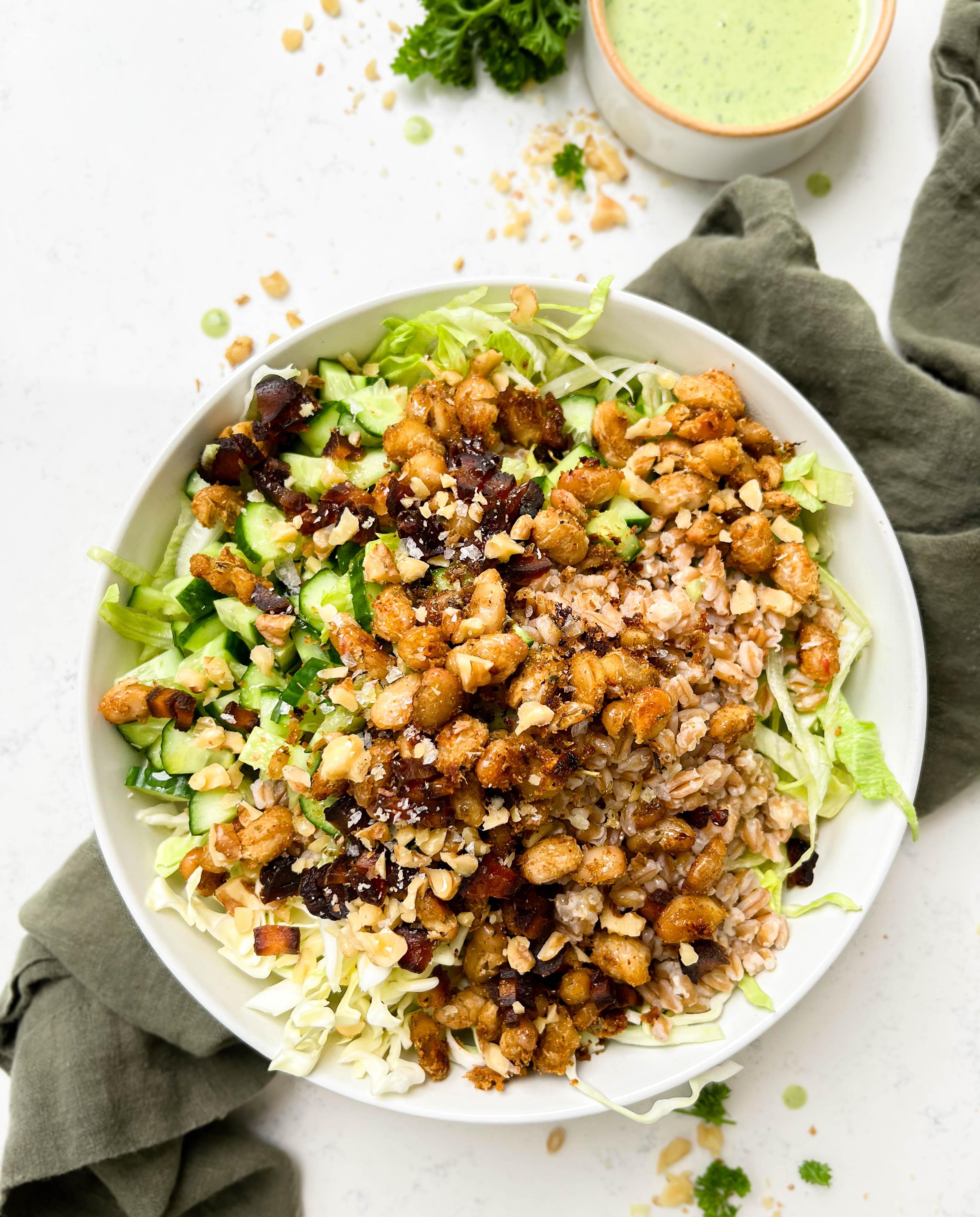 crunchy green cabbage salad with beans and farro next to parsley tahini dressing