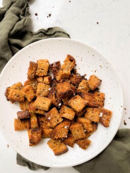 white speckled plate with homemade croutons on a green linen