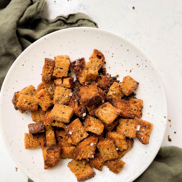 white speckled plate with homemade croutons on a green linen