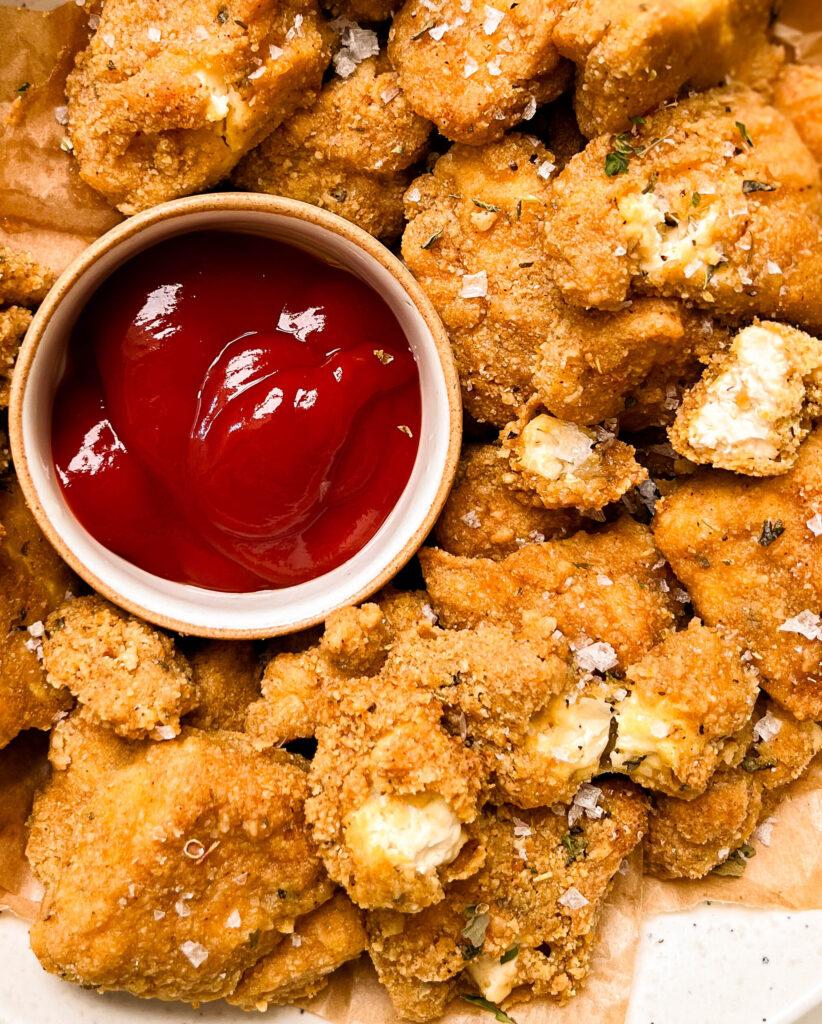 crispy baked tofu nuggets in bowl with a bowl of ketchup