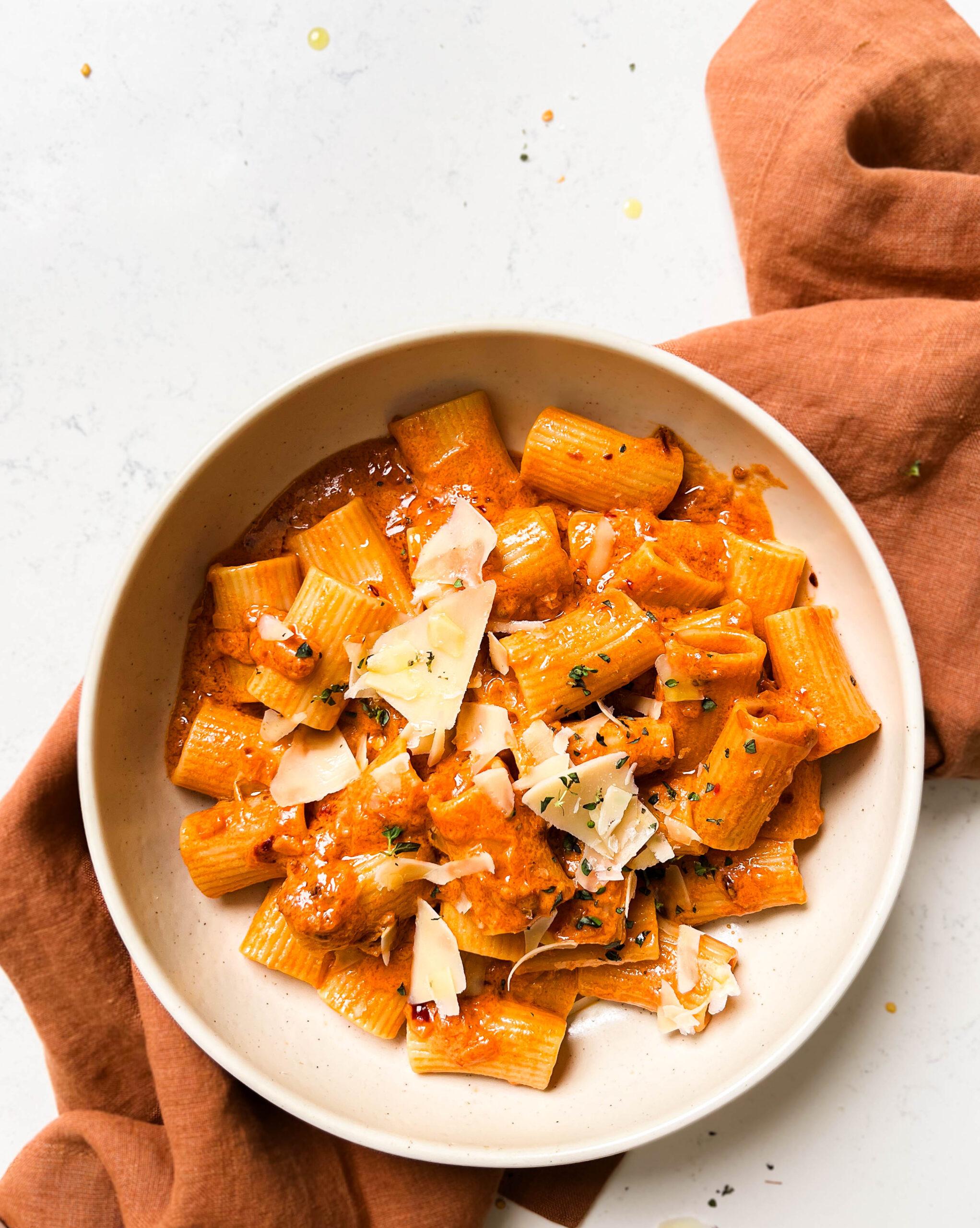 bowl of vegan vodka pasta on a brown linen cloth