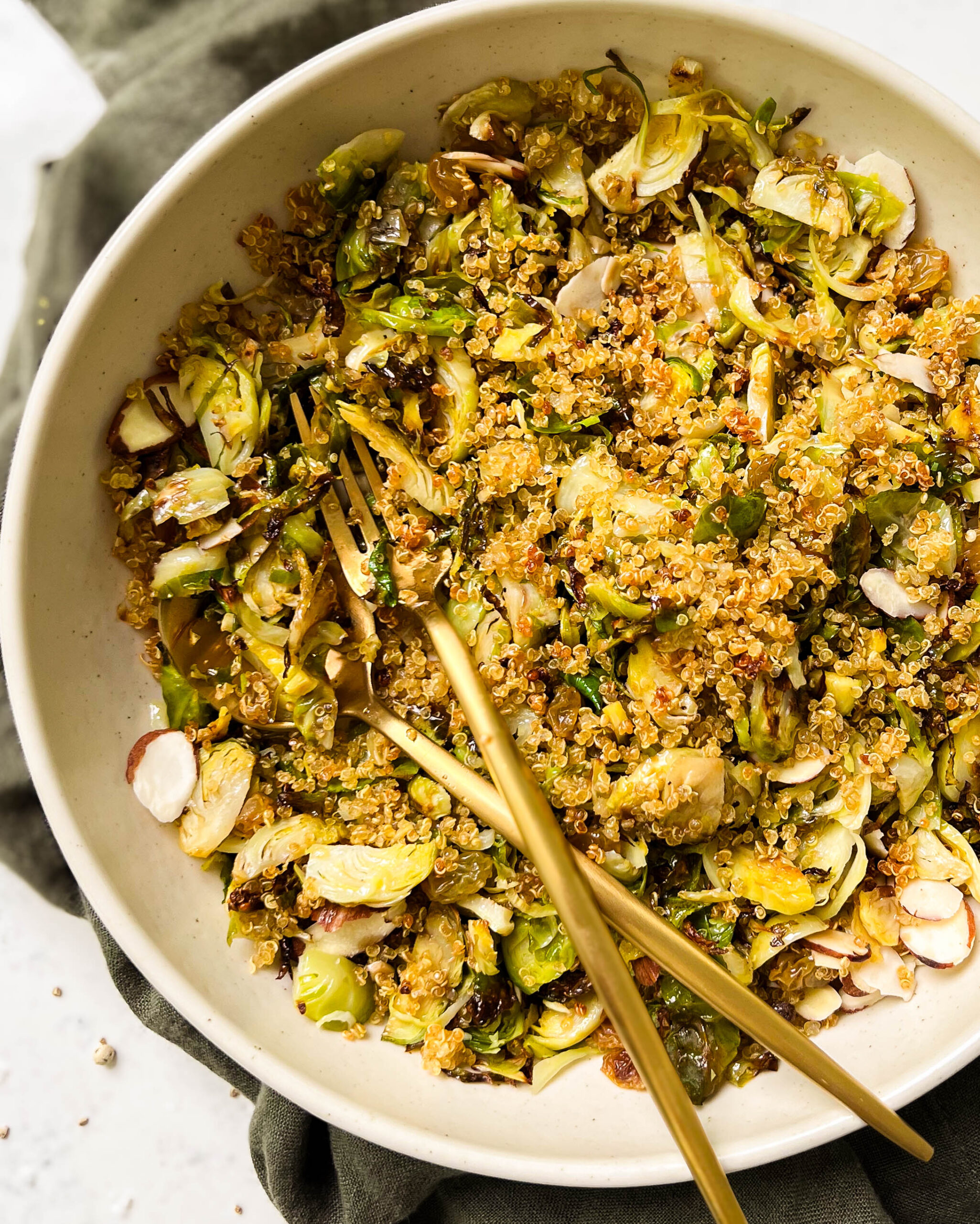 shallow bowl of roasted brussels sprouts salad on a green linen