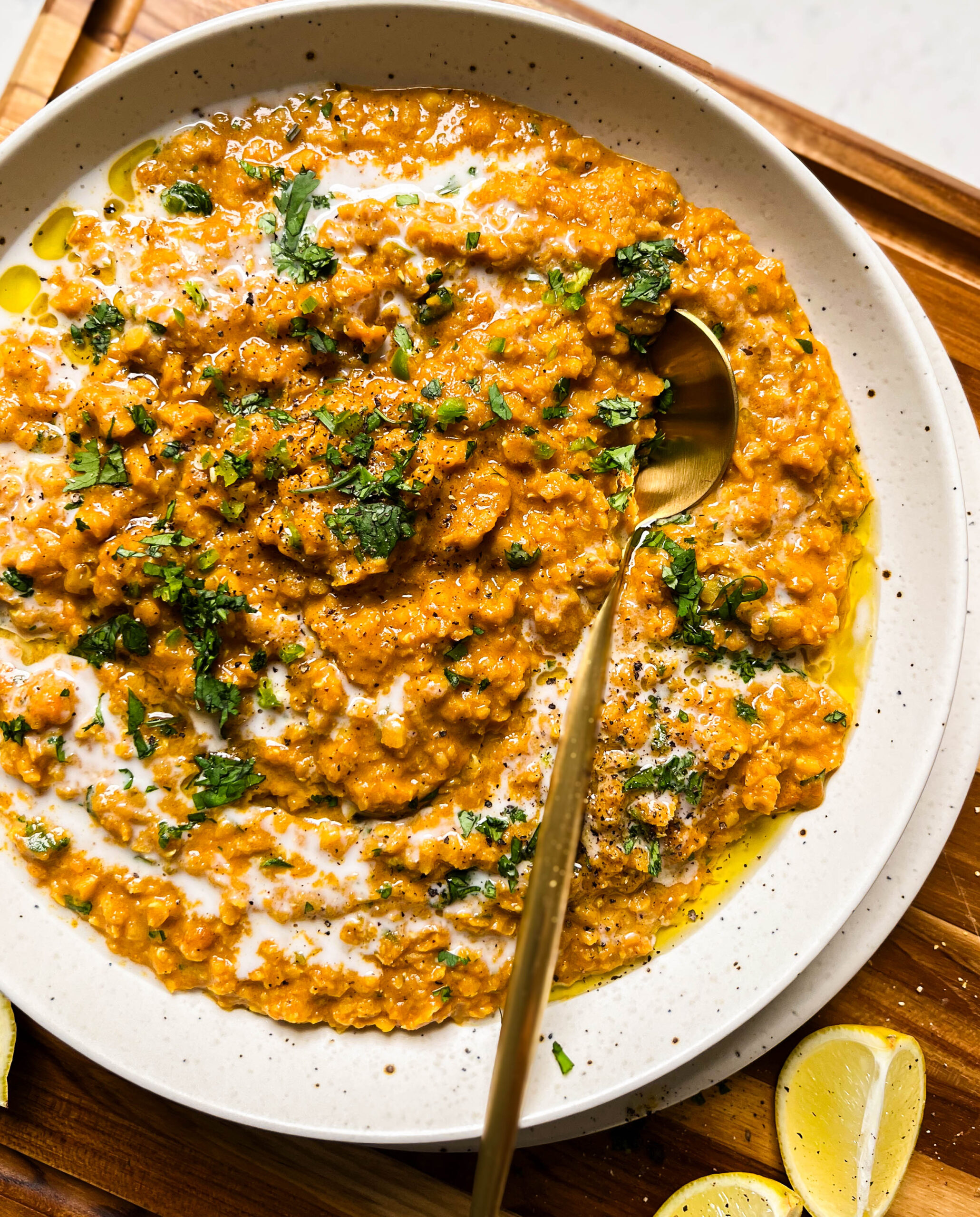 bowl of red lentil curry on a wood cutting board