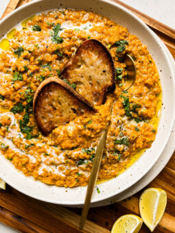 bowl of red lentil curry on a wood cutting board