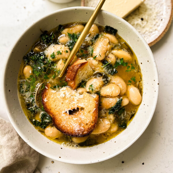 brothy beans with bread in a white bowl