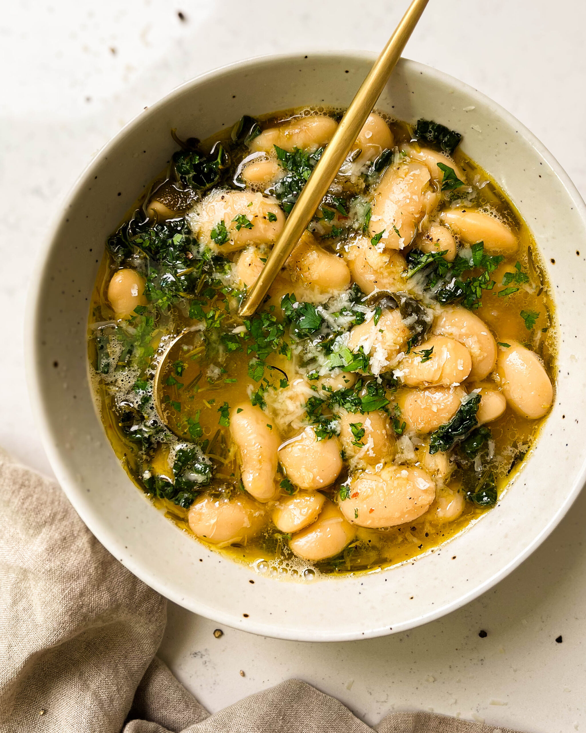 brothy beans in a white bowl