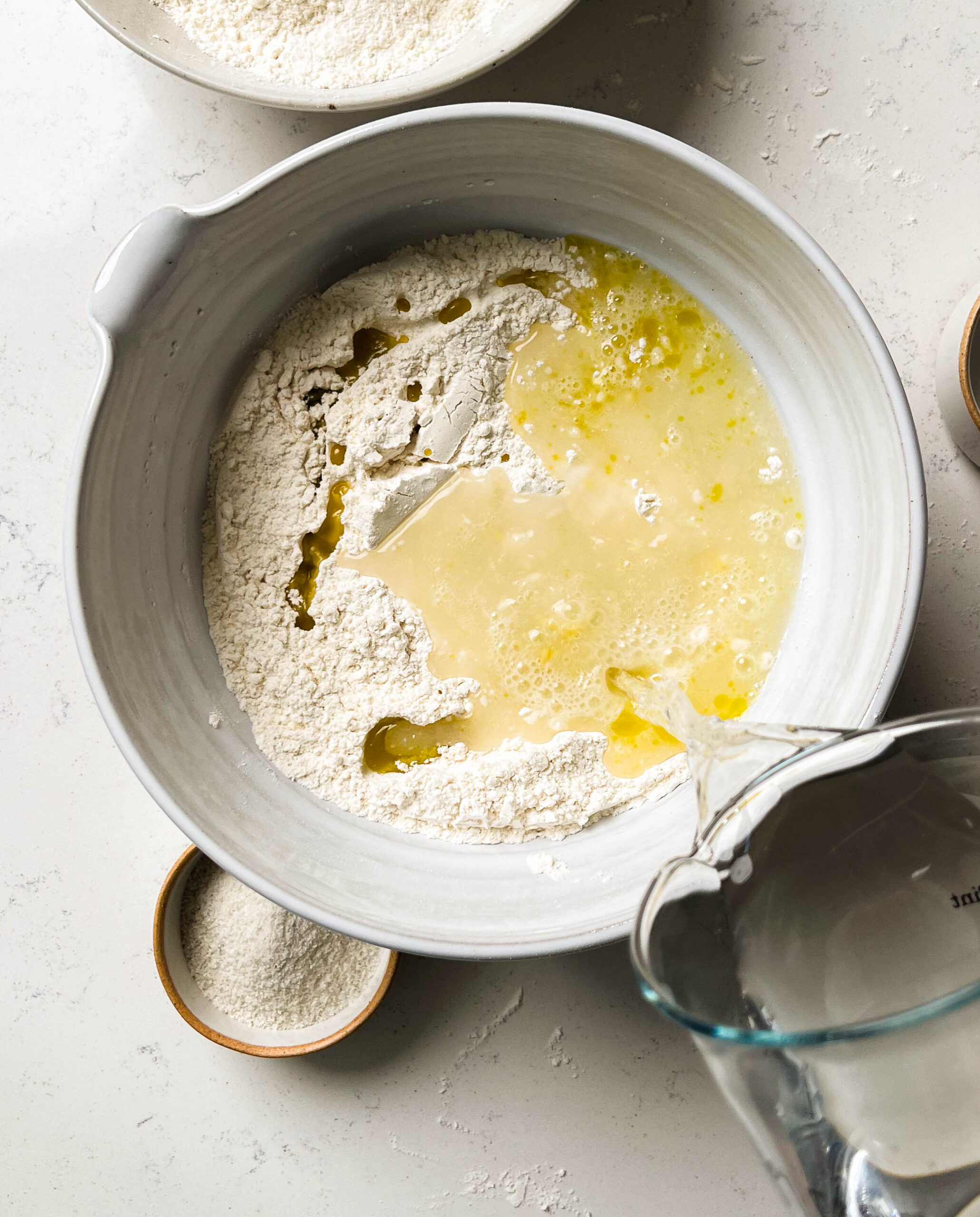 water pouring into a bowl of focaccia bread ingredients