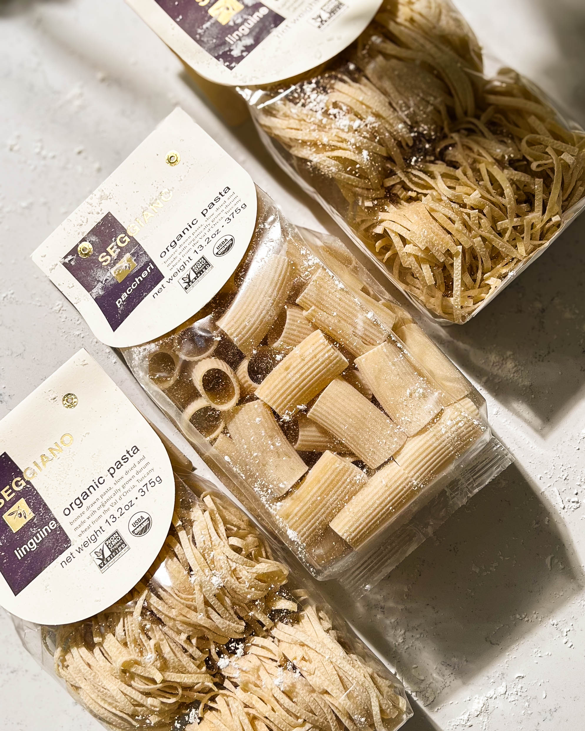 bags of dried pasta on a white counter