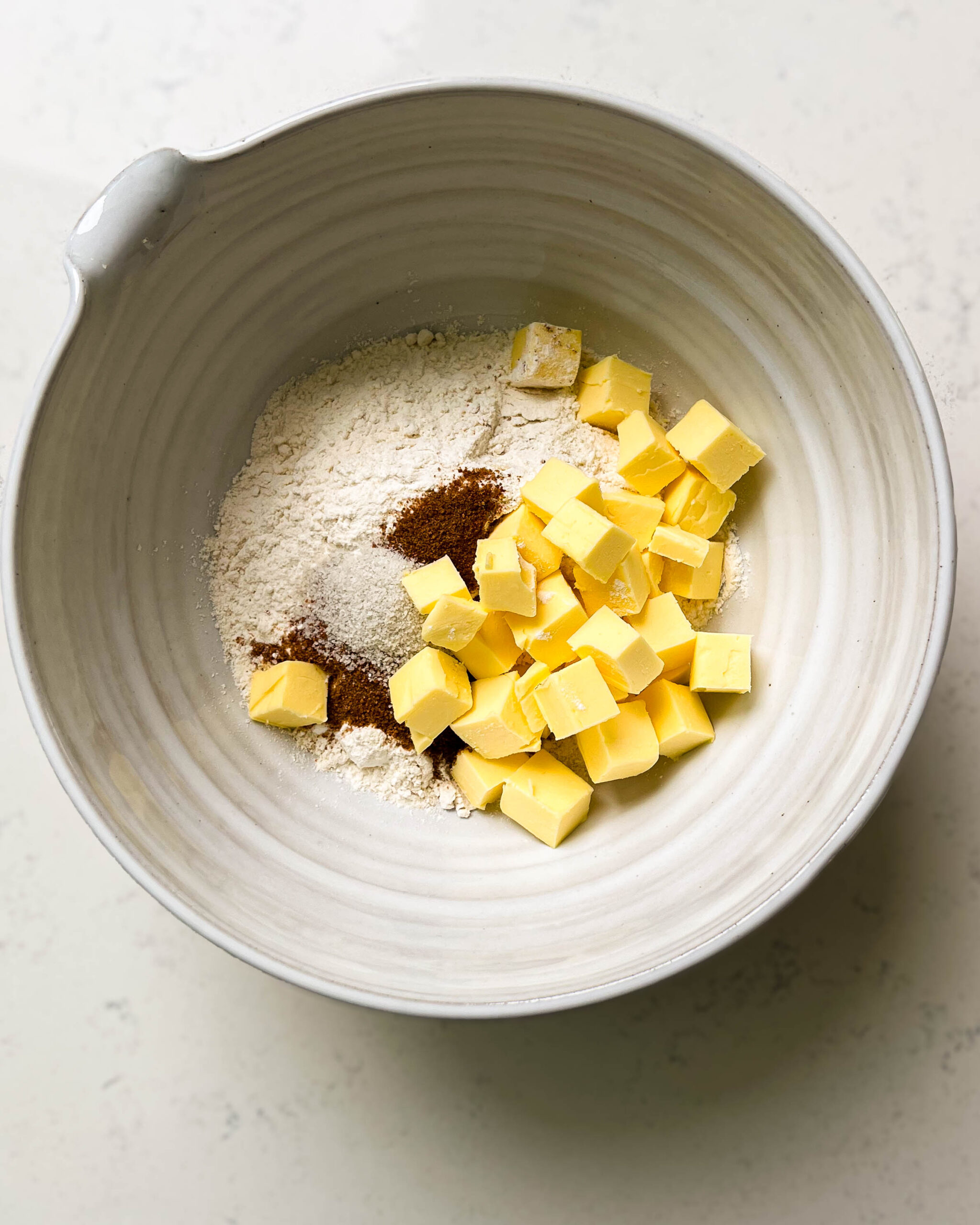 bowl of flour with pieces of butter