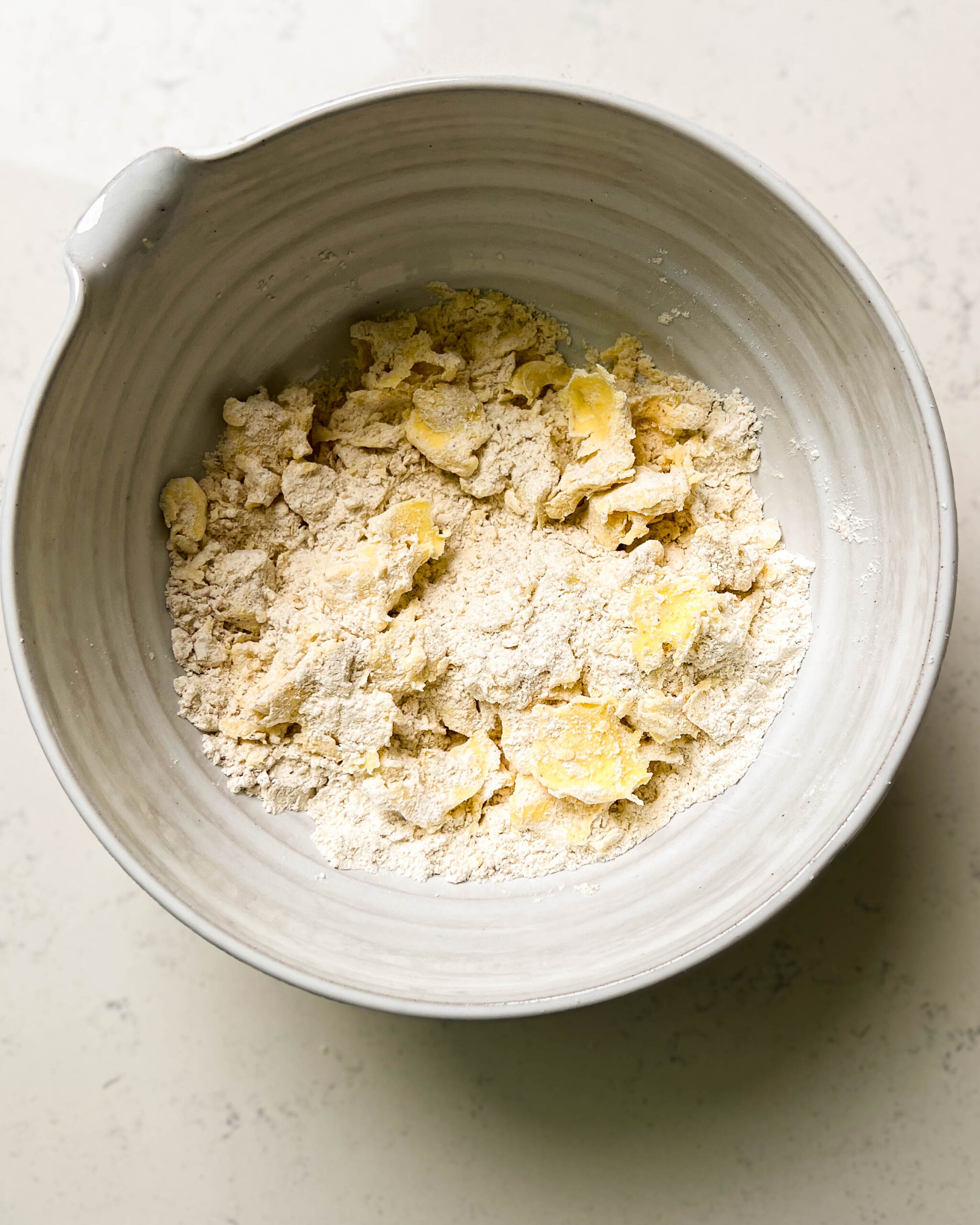 bowl of flour with pieces of butter