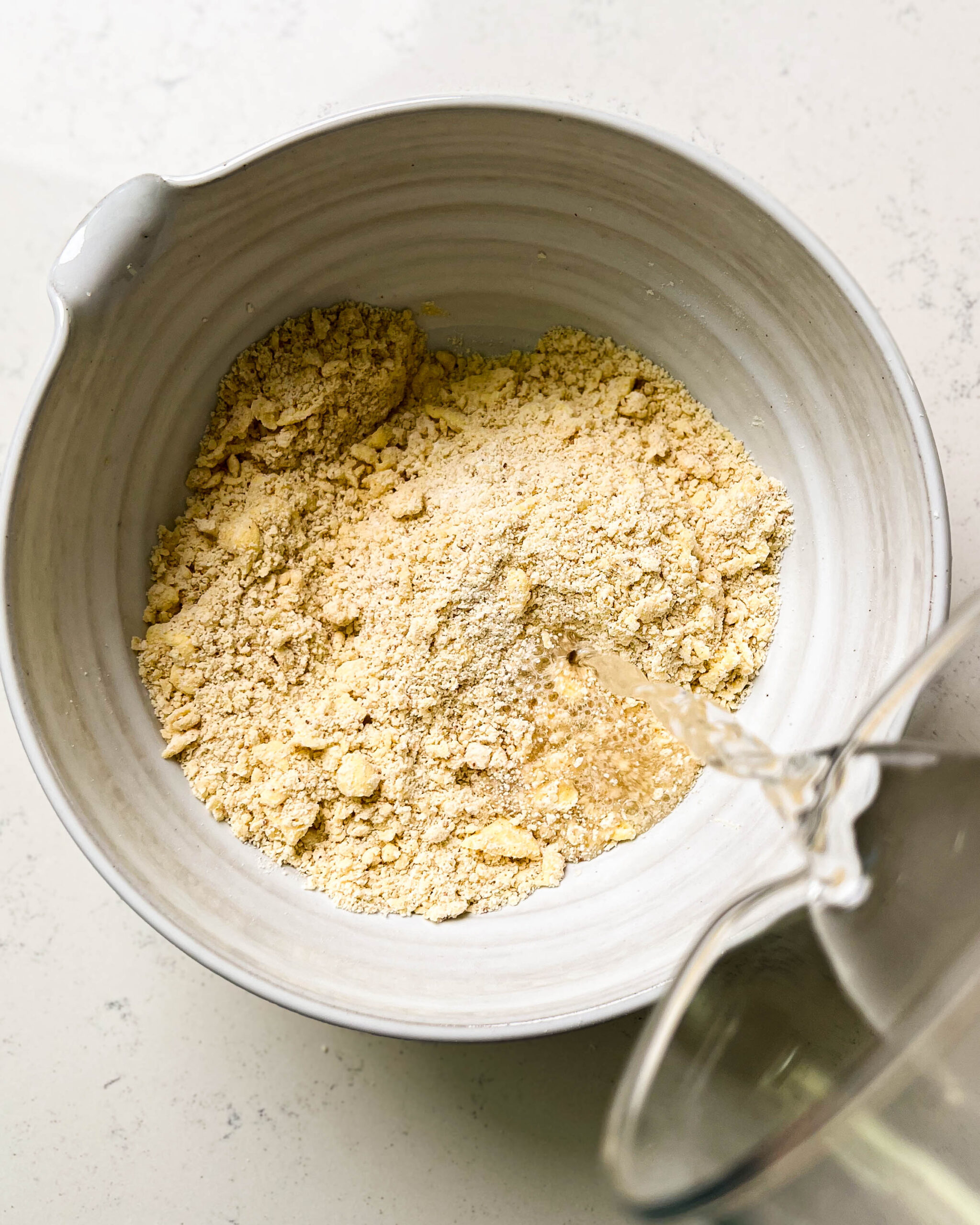 bowl of flour with water streaming in