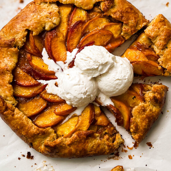 almond peach galette with three scoop of vanilla ice cream on top