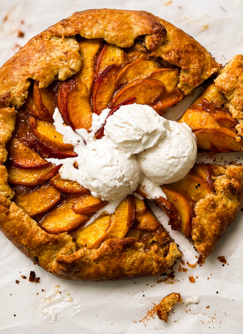 almond peach galette with three scoop of vanilla ice cream on top