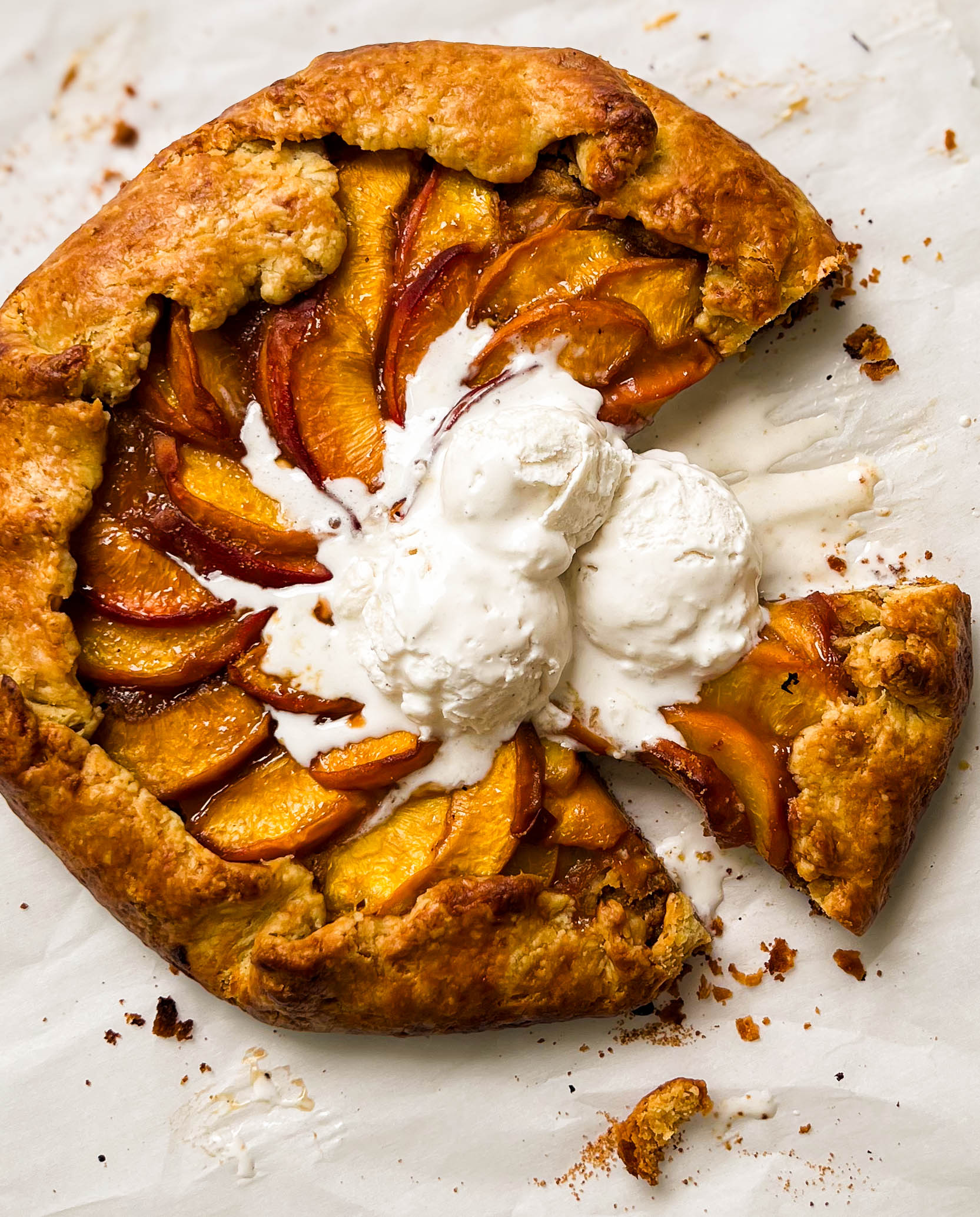 almond peach galette with three scoop of vanilla ice cream on top