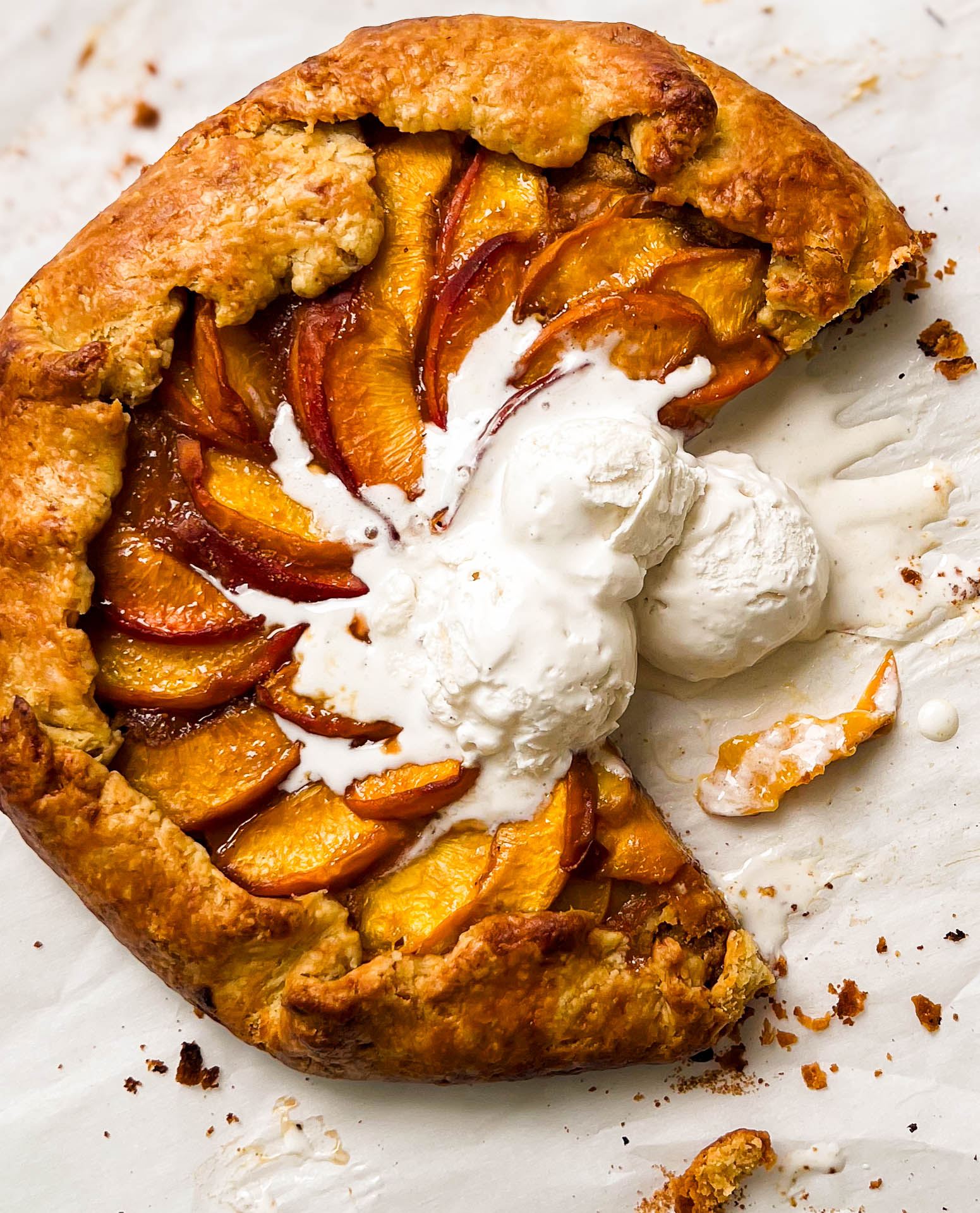 almond peach galette with three scoop of vanilla ice cream on top