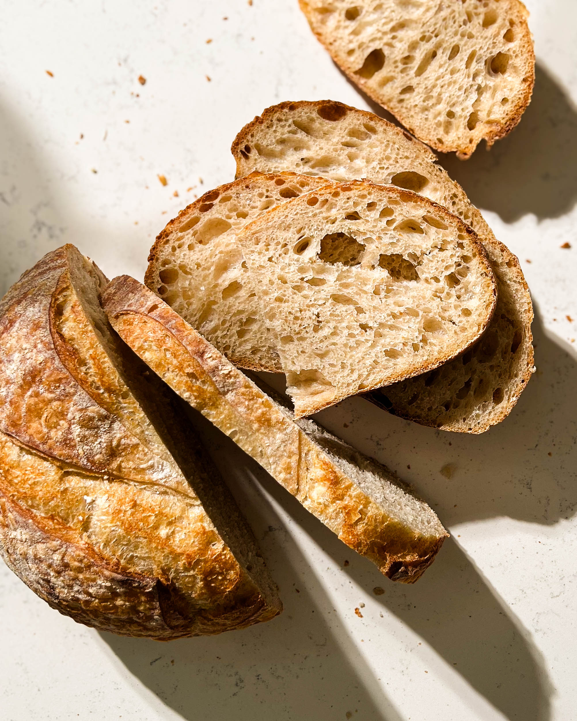 sliced loaf of sourdough bread on a white counter