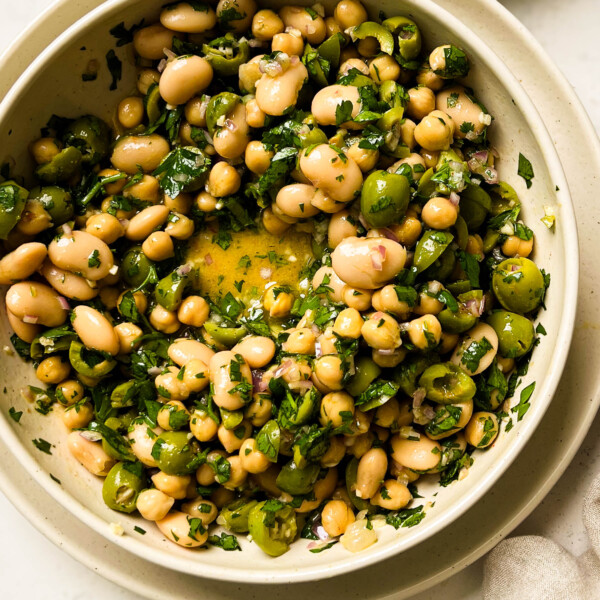 green olive bean salad in a beige bowl